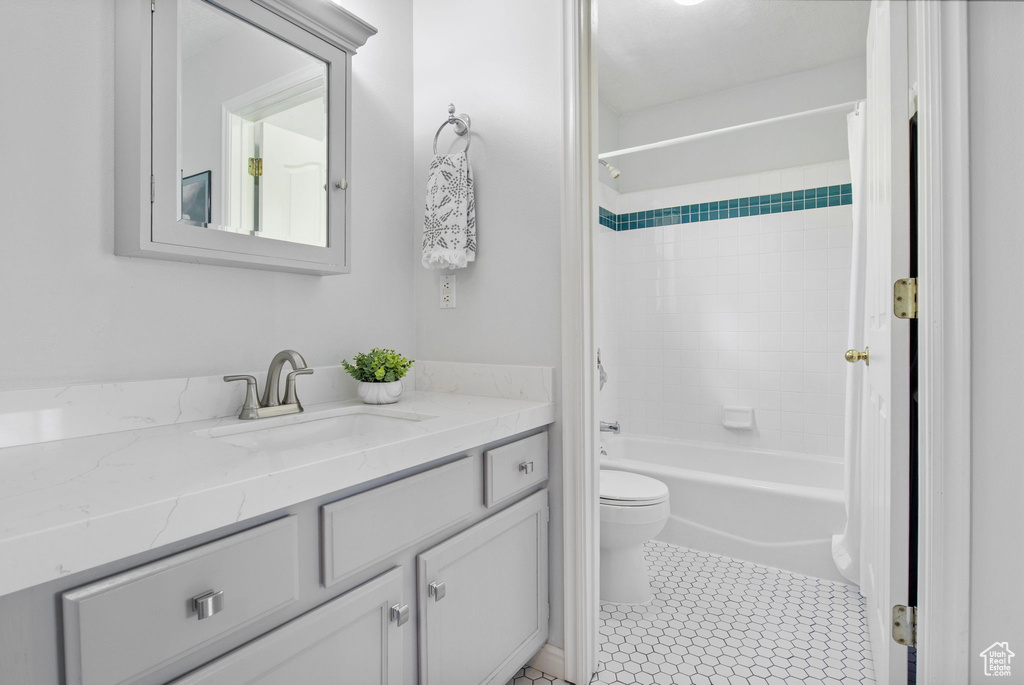 Bathroom with toilet, vanity, washtub / shower combination, and tile patterned floors
