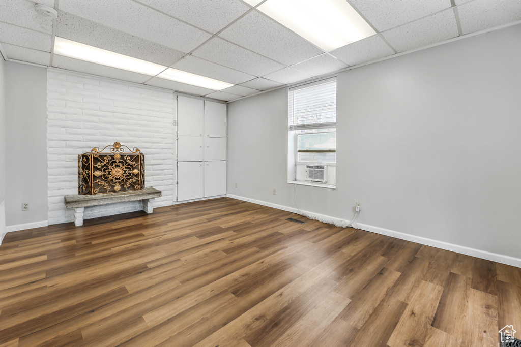 Basement with baseboards, a paneled ceiling, and wood finished floors
