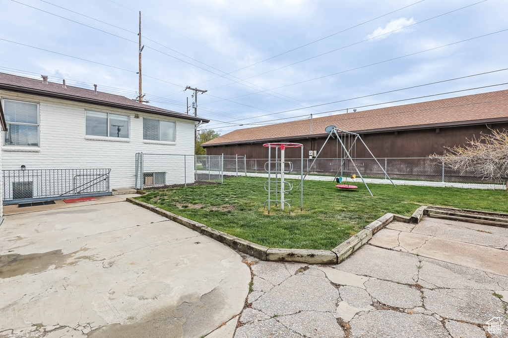 Back of house featuring fence, a patio, and a lawn
