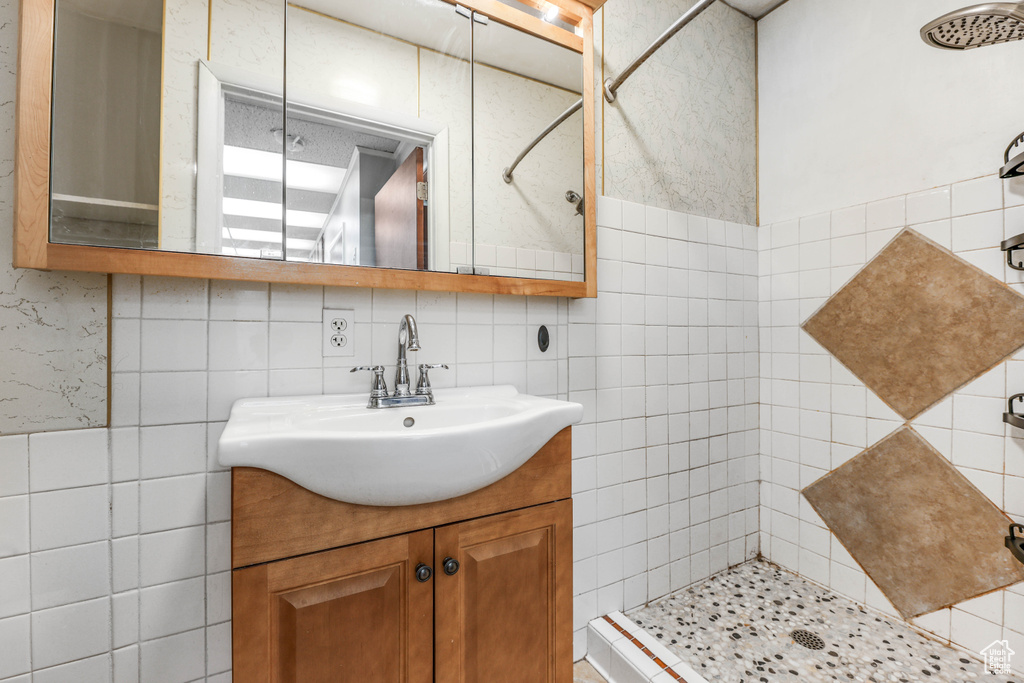 Full bathroom with vanity, tile walls, and a stall shower