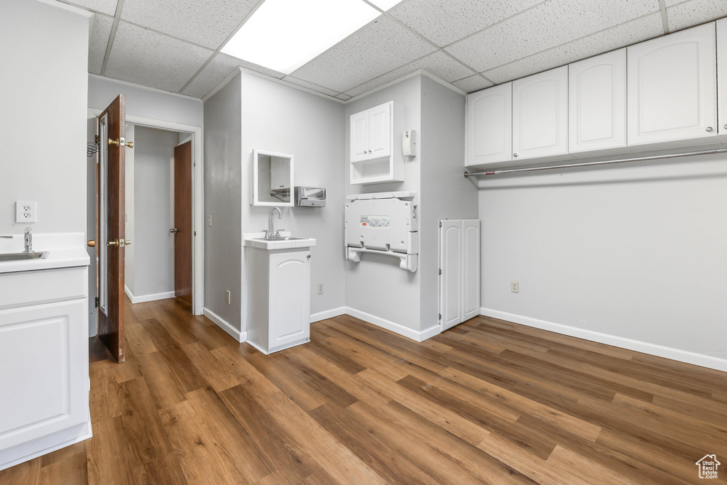 Washroom with baseboards, a sink, and wood finished floors