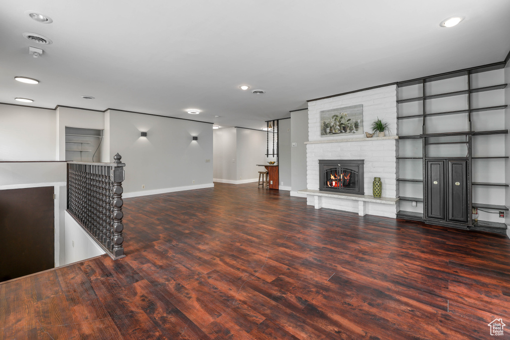 Unfurnished living room with a fireplace, recessed lighting, baseboards, wood finished floors, and visible vents
