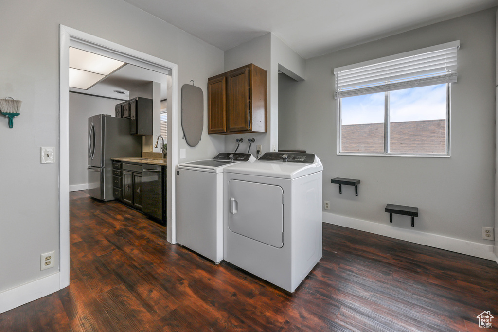 Clothes washing area featuring independent washer and dryer, baseboards, plenty of natural light, and cabinet space