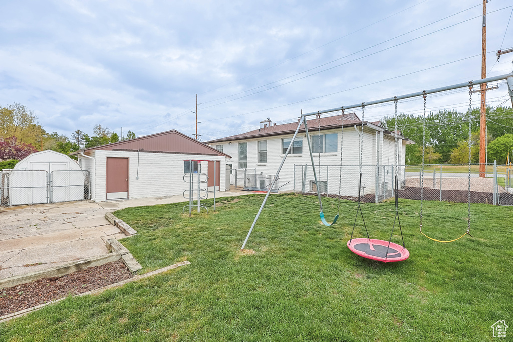 View of yard featuring an outdoor structure, fence, and a gate
