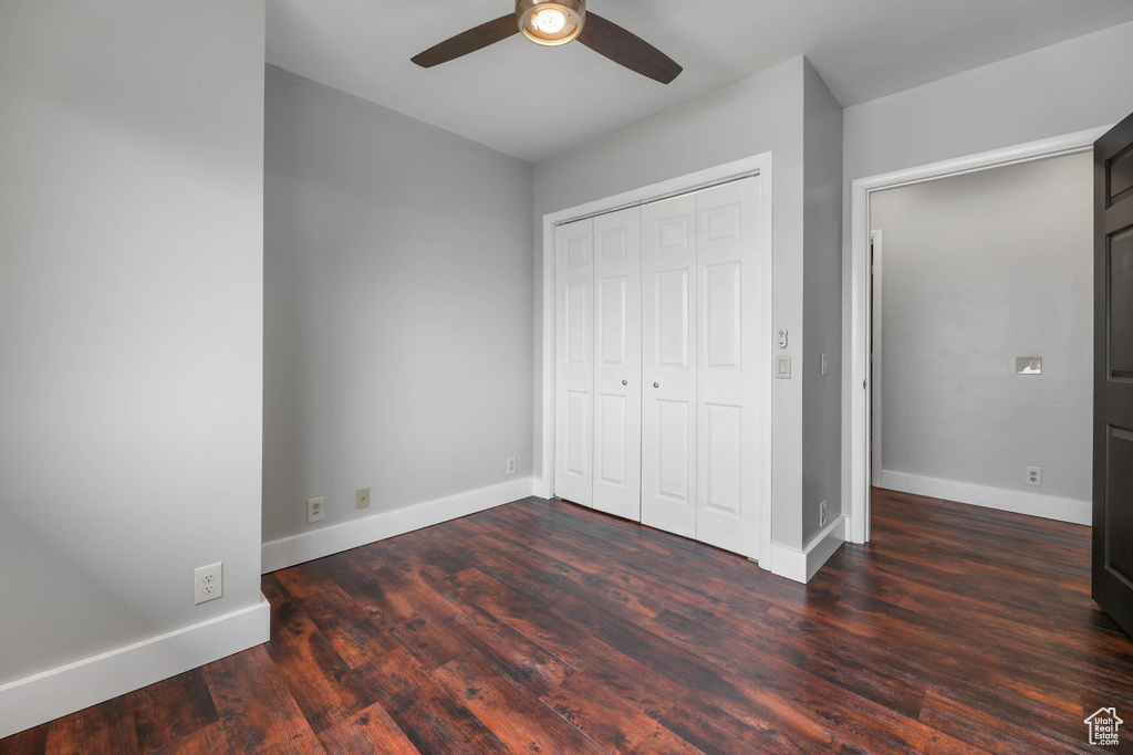 Unfurnished bedroom featuring baseboards, a ceiling fan, wood finished floors, and a closet