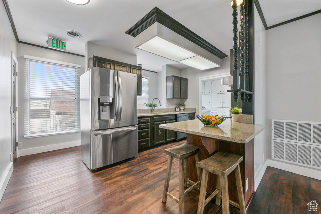 Kitchen featuring a sink, dark wood finished floors, stainless steel appliances, baseboards, and visible vents