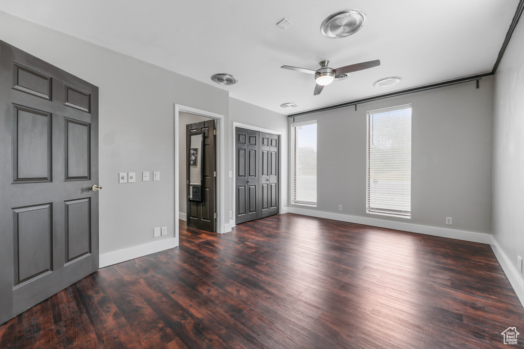 Unfurnished bedroom featuring baseboards, ceiling fan, and wood finished floors