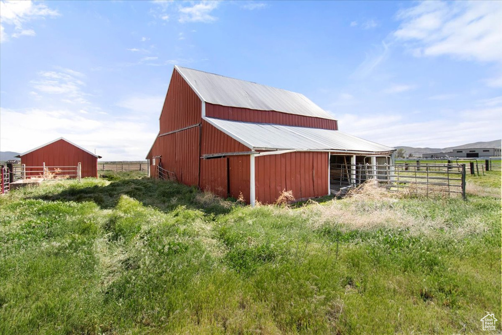 View of pole building with fence and an exterior structure