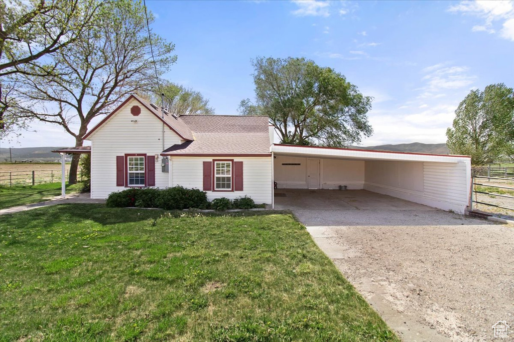 View of front facade with concrete driveway and an attached carport