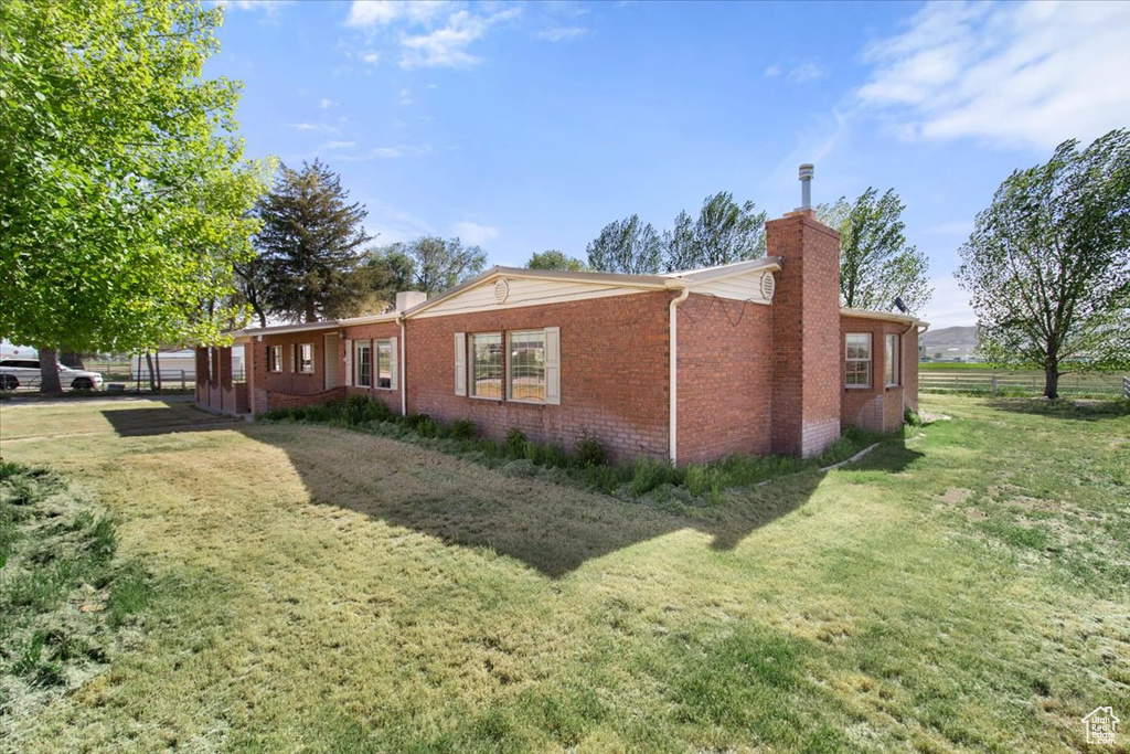 View of home\'s exterior featuring a chimney and brick siding