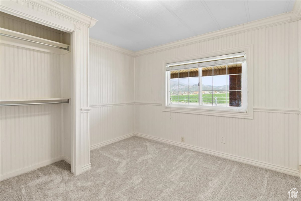 Unfurnished bedroom featuring crown molding, carpet, and baseboards