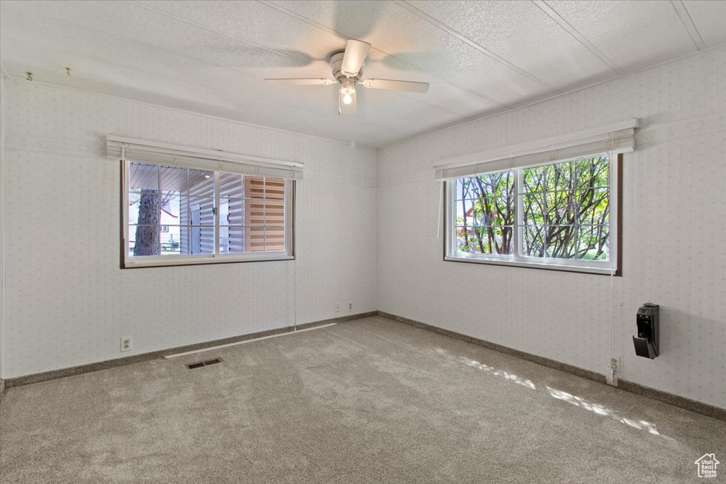 Carpeted empty room featuring ceiling fan