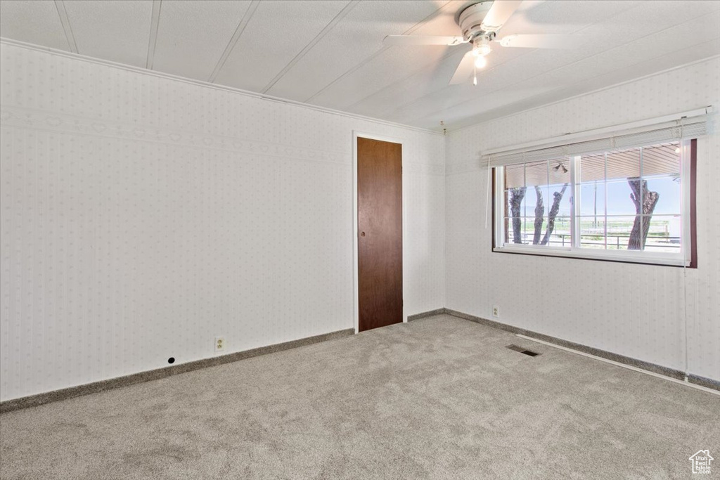 Empty room featuring carpet and ceiling fan