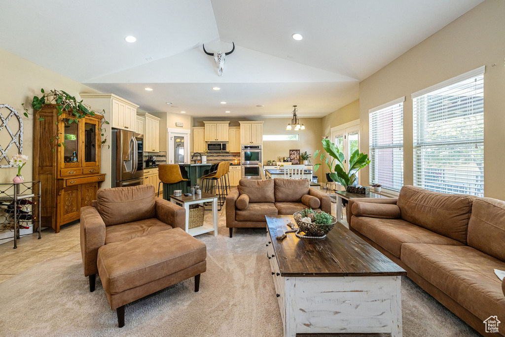 Living room featuring lofted ceiling, recessed lighting, and light colored carpet