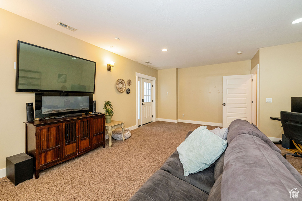 Living area with carpet floors, baseboards, and recessed lighting