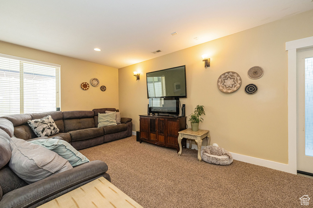 Living area with carpet floors, plenty of natural light, baseboards, and recessed lighting