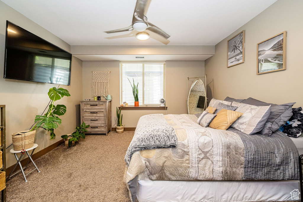 Bedroom with carpet flooring, baseboards, and ceiling fan