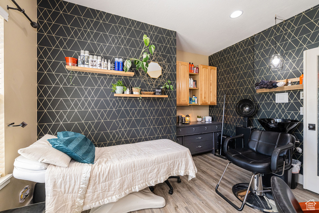 Bedroom featuring wood finished floors, tile walls, an accent wall, and recessed lighting