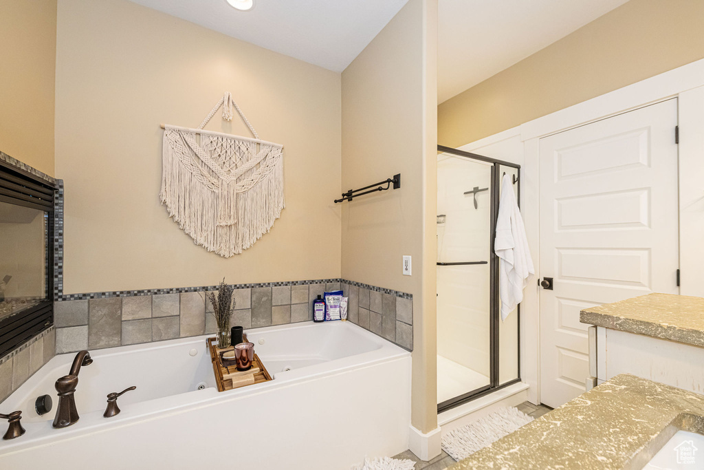 Full bath with a stall shower, a jetted tub, and vanity