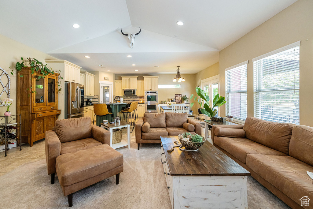 Living room featuring vaulted ceiling, recessed lighting, and light colored carpet