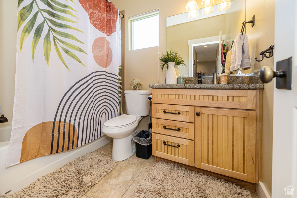 Full bath featuring toilet, vanity, and shower / bath combo with shower curtain