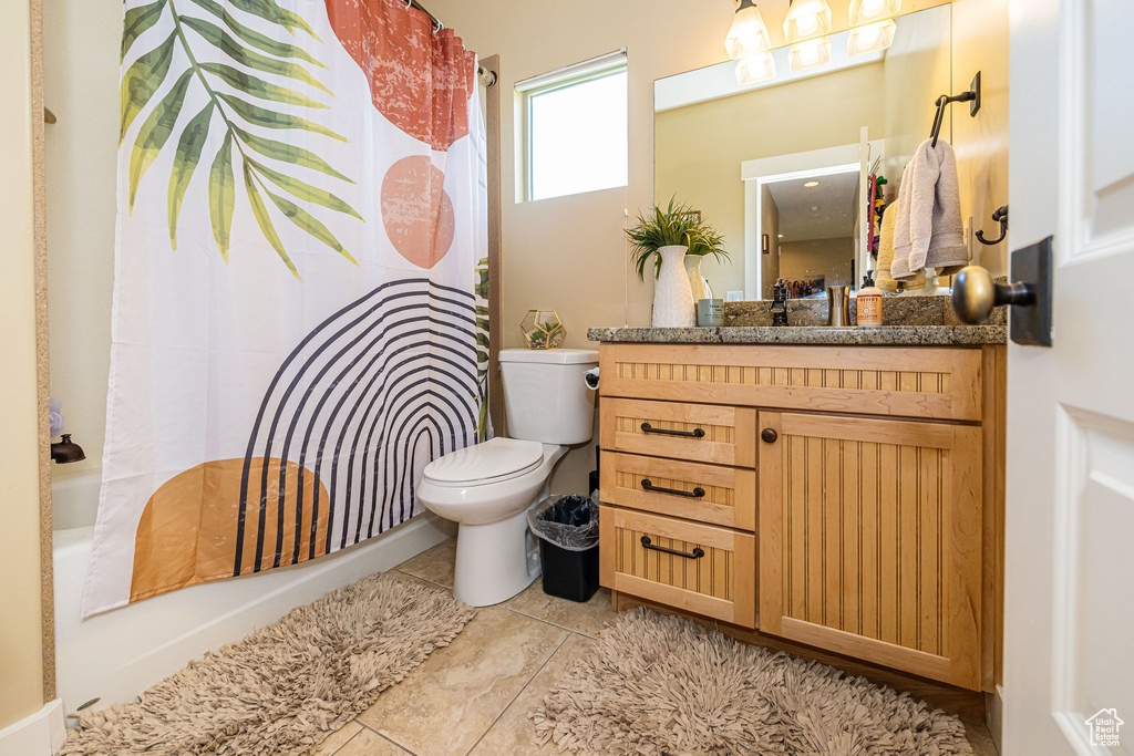 Full bath with toilet, vanity, shower / tub combo with curtain, and tile patterned floors