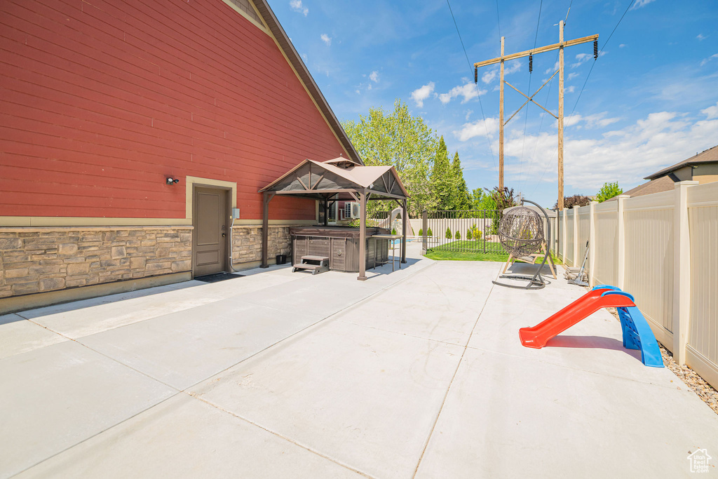 View of patio with a fenced backyard and a hot tub