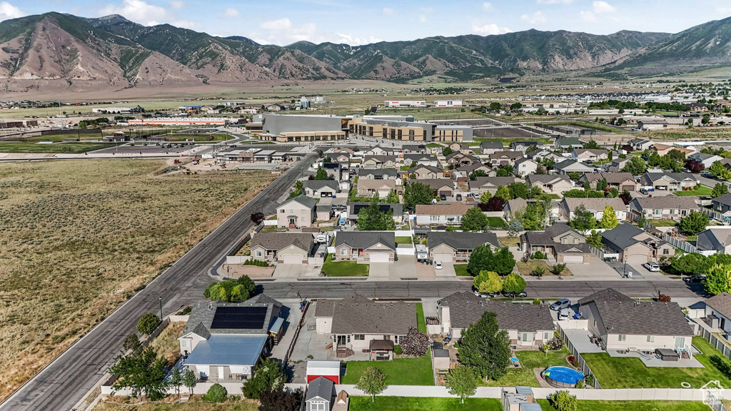 Aerial view of property and surrounding area with mountains and nearby suburban area