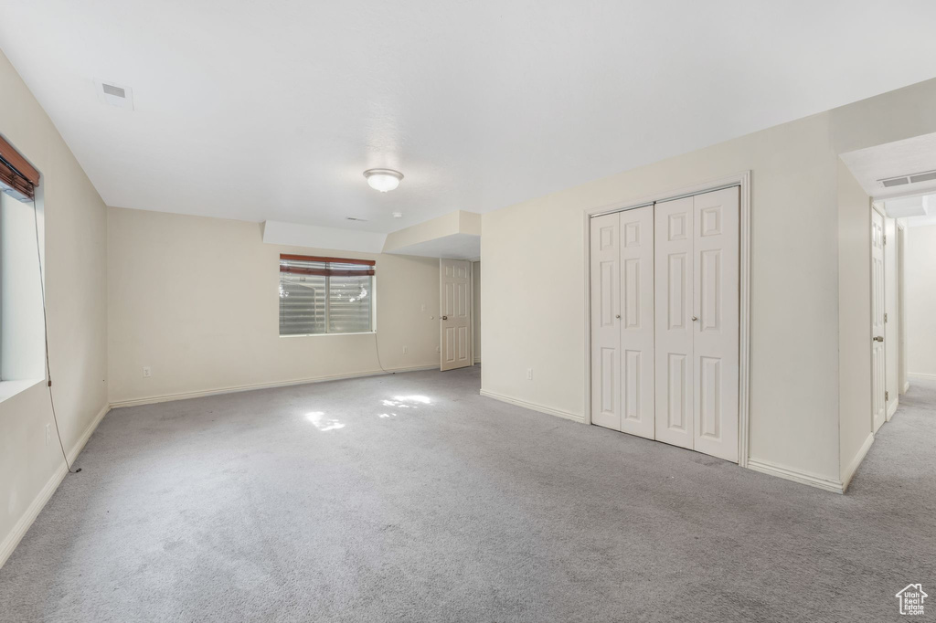 Unfurnished bedroom with carpet floors, baseboards, and a closet
