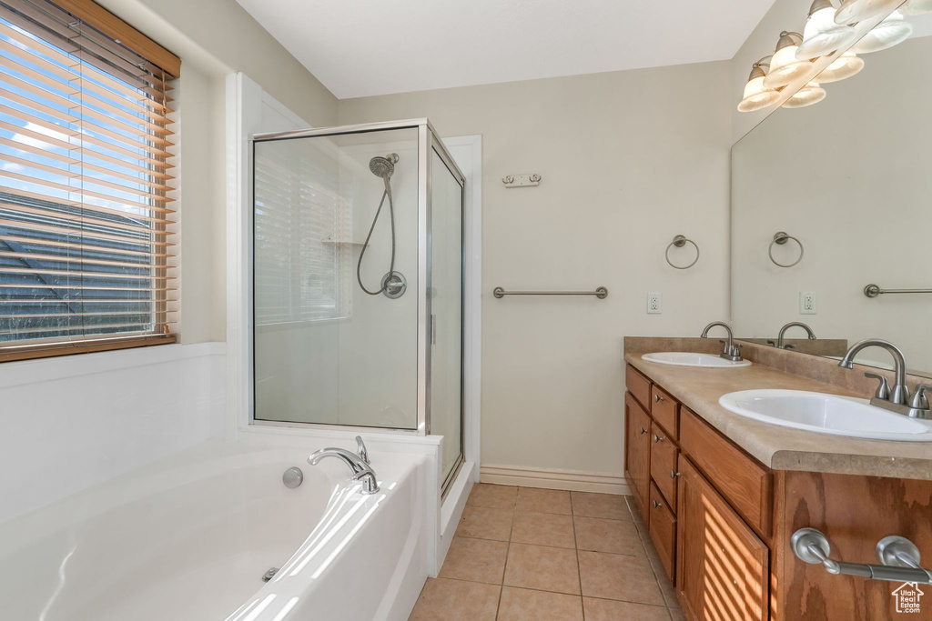 Full bath featuring tile patterned floors, a stall shower, a bath, and double vanity