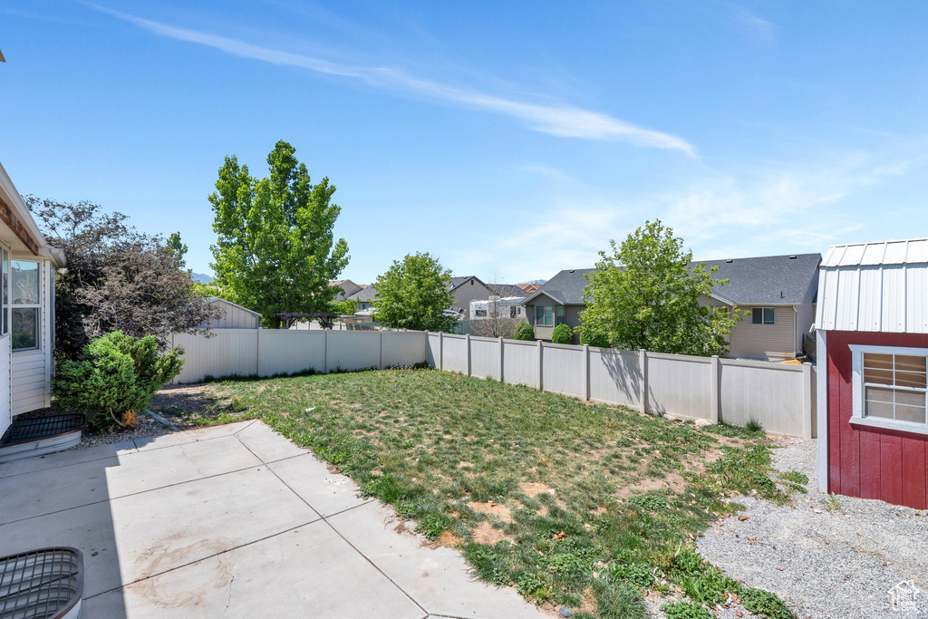 Fenced backyard with a patio area and a residential view