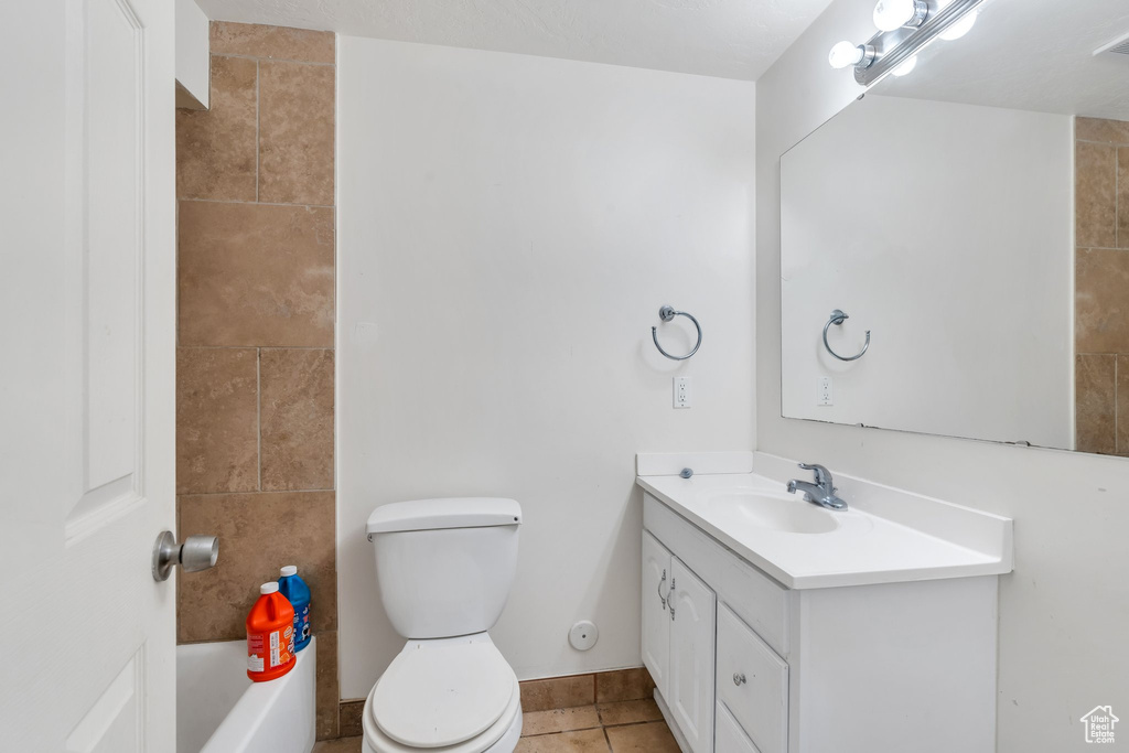 Full bath featuring vanity, tile patterned flooring, toilet, and a bath