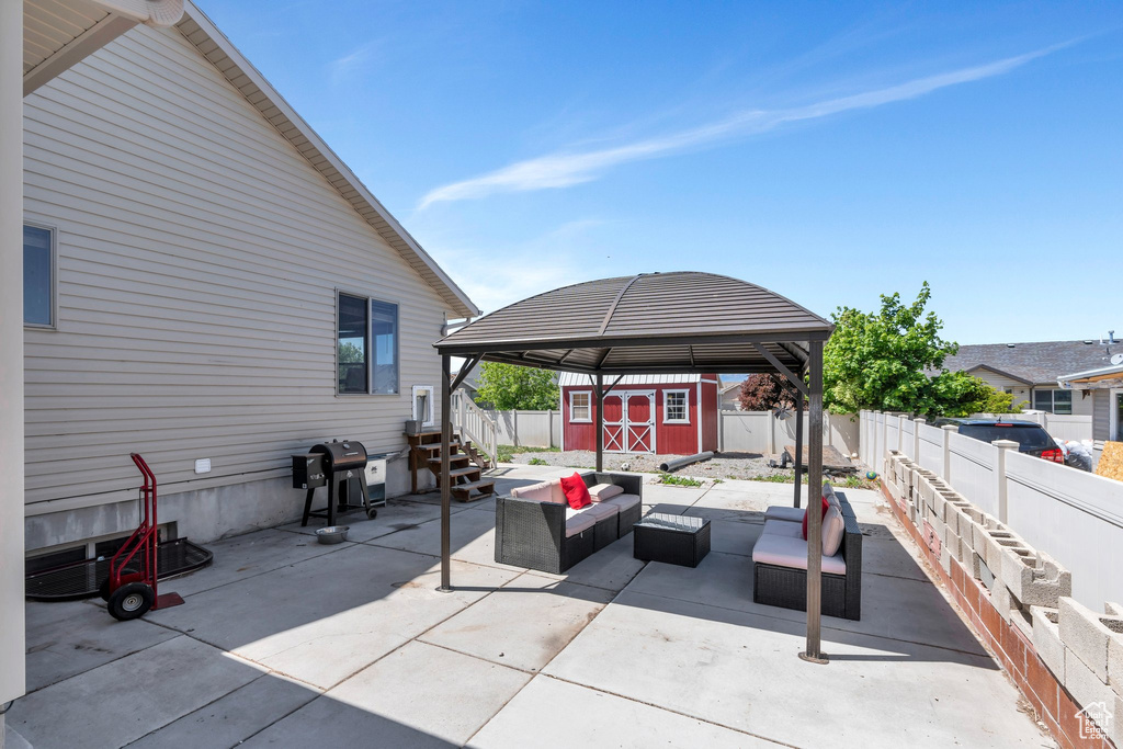 View of patio / terrace with outdoor lounge area, a storage unit, a gazebo, a grill, and a fenced backyard