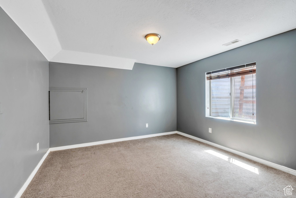 Spare room featuring carpet flooring and baseboards