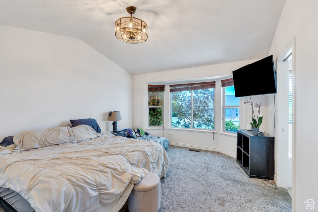 Carpeted bedroom featuring lofted ceiling and baseboards