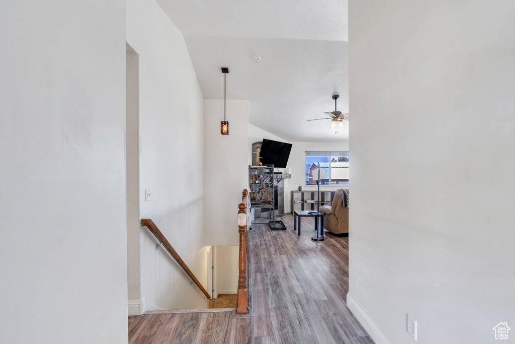 Hallway featuring an upstairs landing, wood finished floors, and baseboards