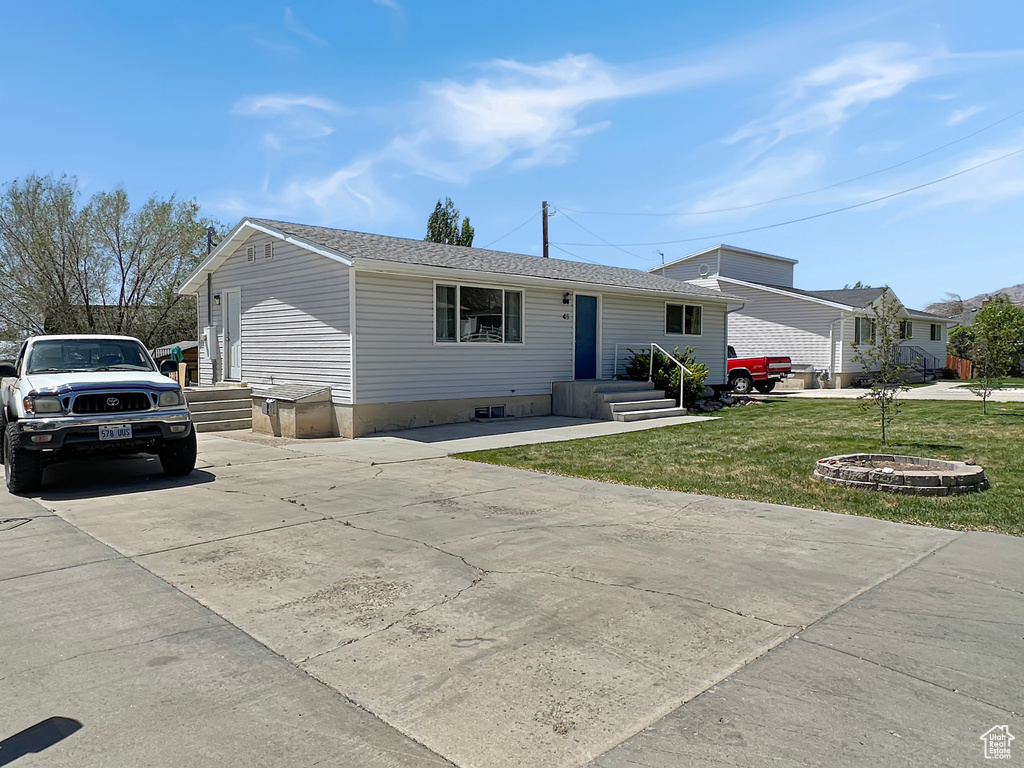View of front of property featuring a front yard and concrete driveway