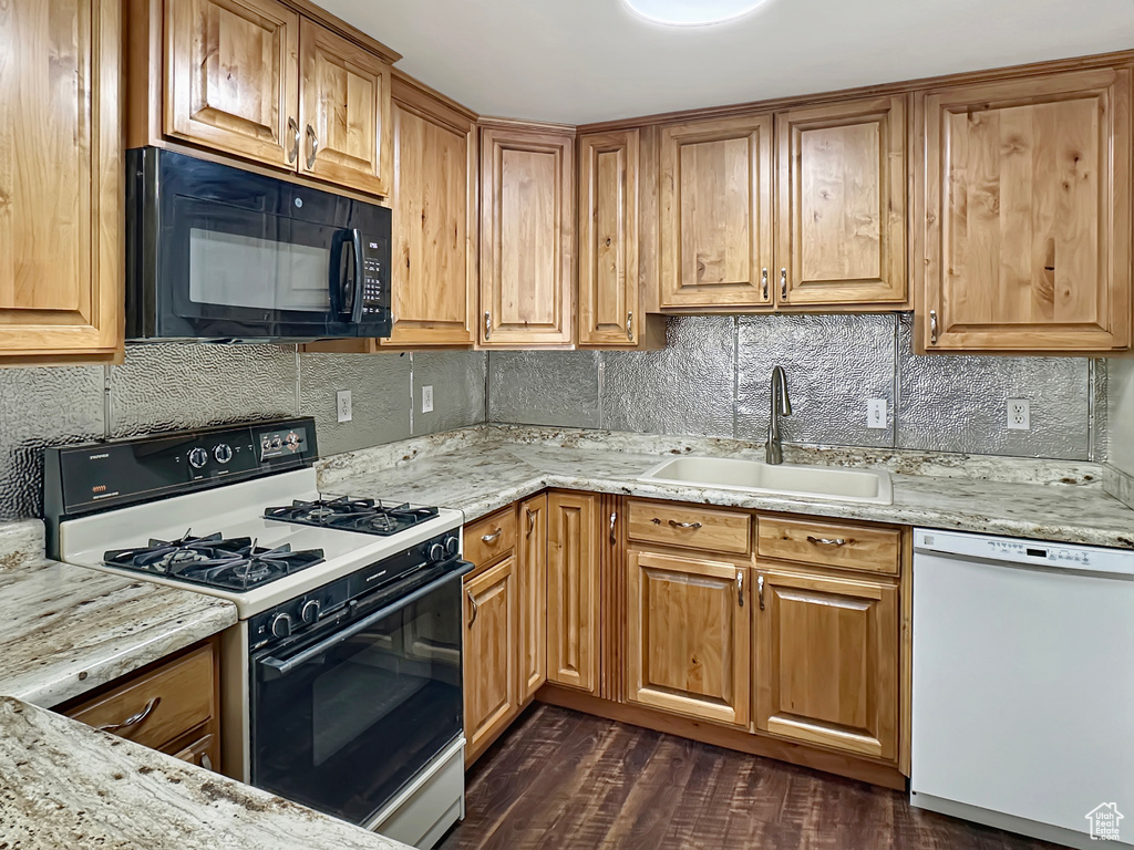 Kitchen featuring black microwave, range with gas cooktop, dishwasher, a sink, and tasteful backsplash