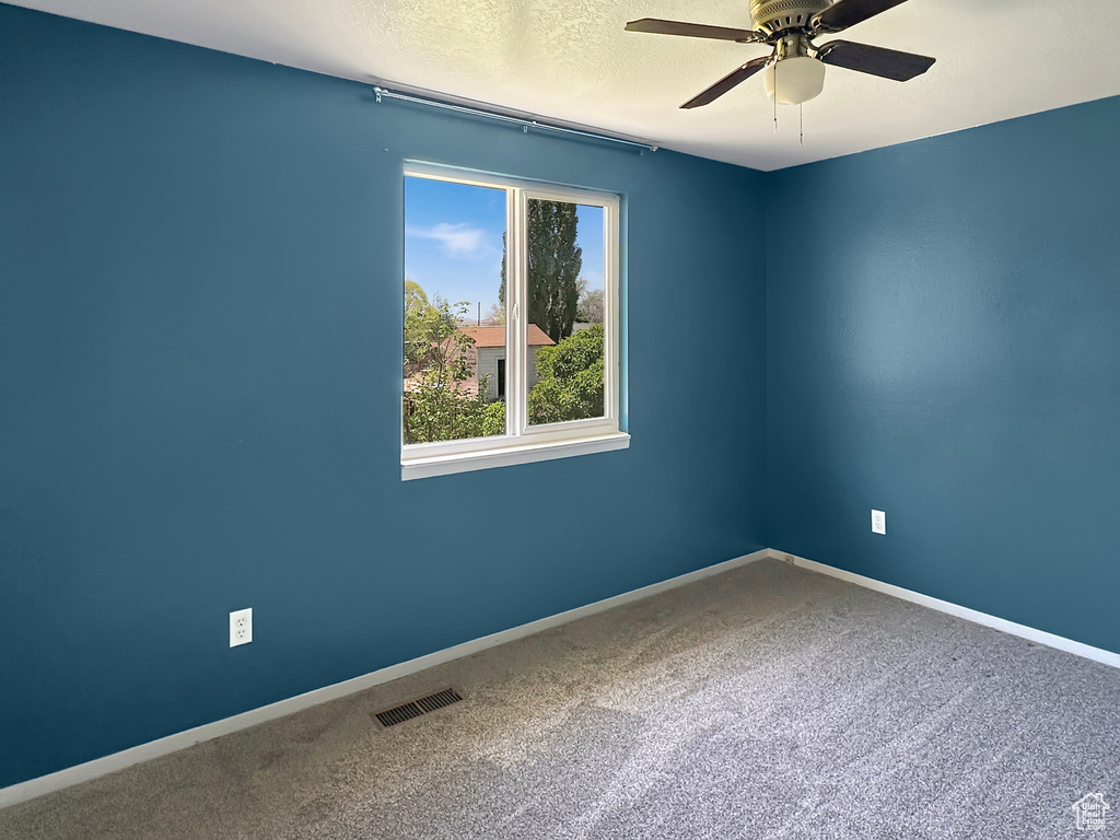 Spare room featuring ceiling fan, carpet floors, a textured ceiling, and baseboards