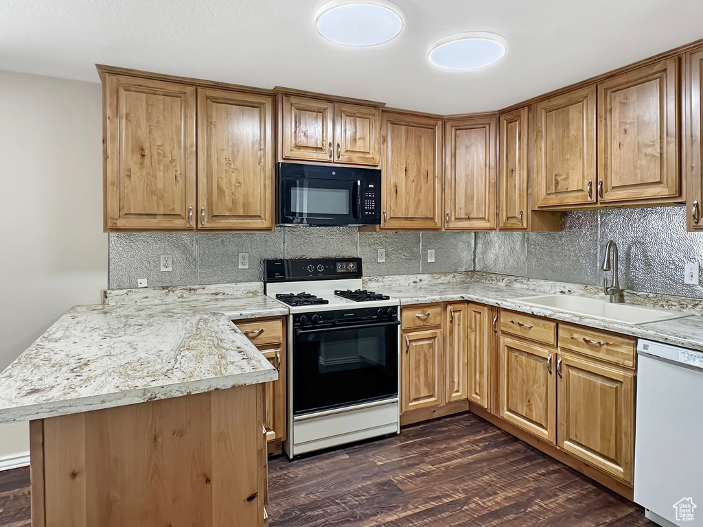 Kitchen with black microwave, gas stove, dishwasher, a sink, and decorative backsplash