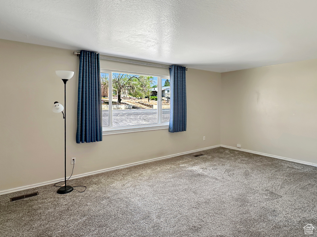 Carpeted empty room featuring baseboards