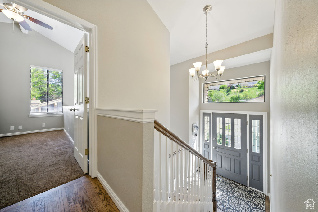 Foyer with a chandelier, high vaulted ceiling, a ceiling fan, baseboards, and wood finished floors