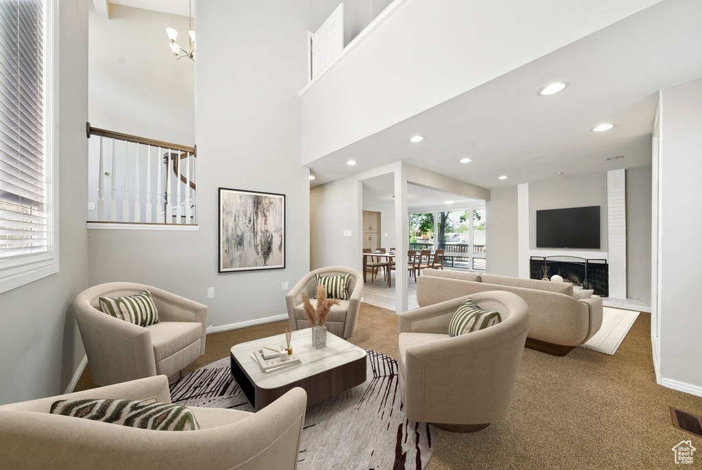 Carpeted living area with a chandelier, baseboards, and recessed lighting