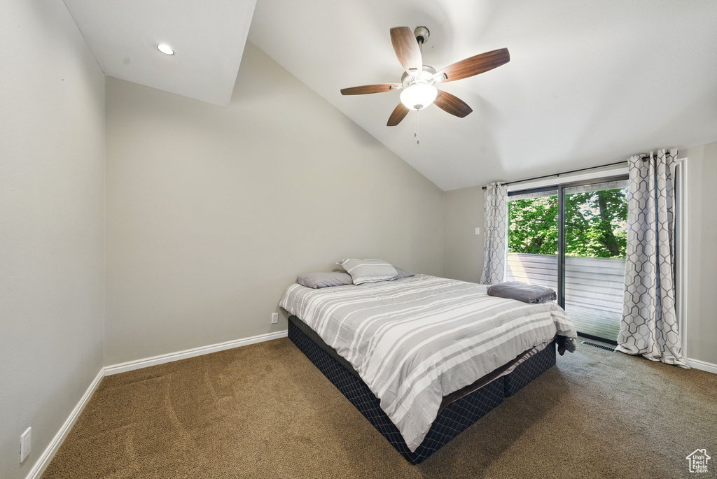 Carpeted bedroom featuring access to exterior, vaulted ceiling, baseboards, and a ceiling fan
