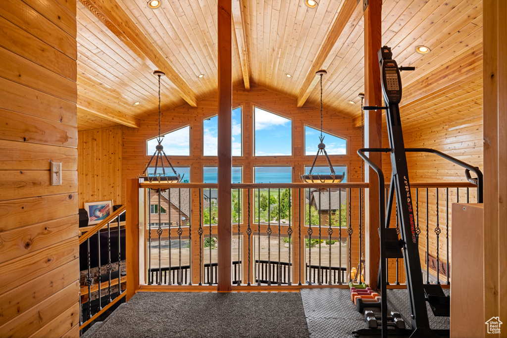 Exercise room featuring high vaulted ceiling, carpet floors, wood walls, and recessed lighting