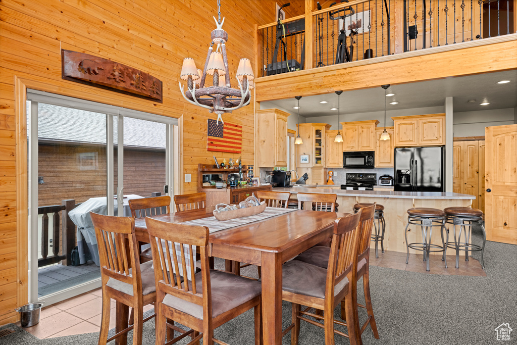 Dining room with a high ceiling and wood walls