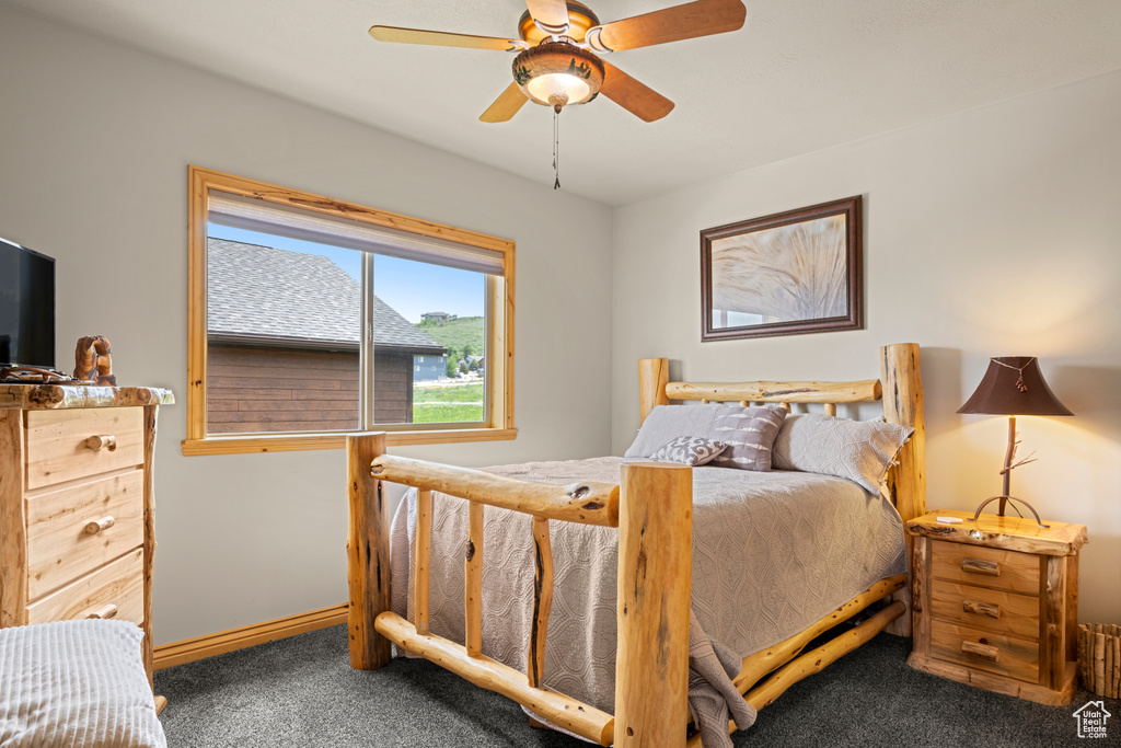 Carpeted bedroom with baseboards and a ceiling fan