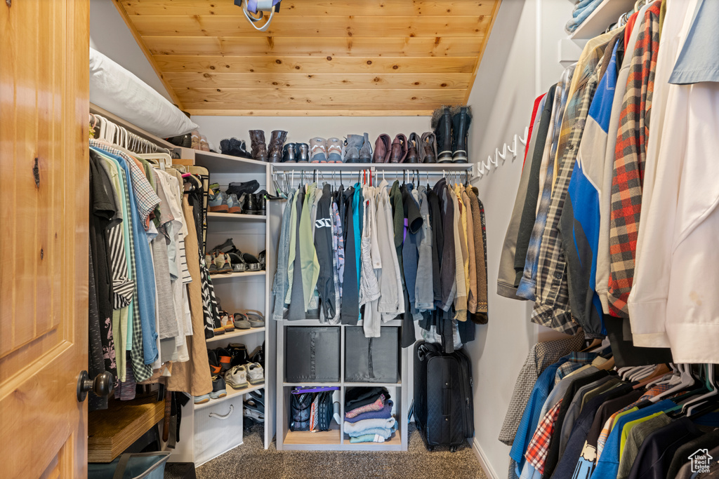 Spacious closet with vaulted ceiling and carpet flooring
