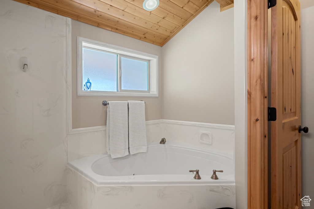 Bathroom with wood ceiling, a bath, and lofted ceiling