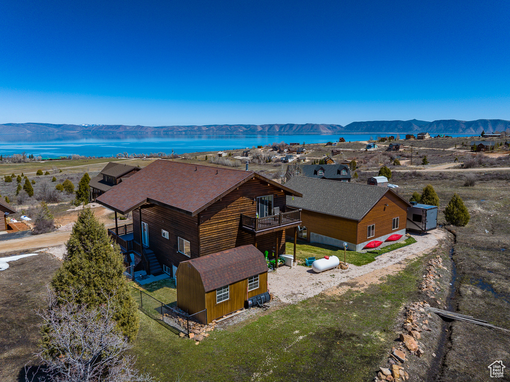 Aerial view of property and surrounding area featuring a water and mountain view